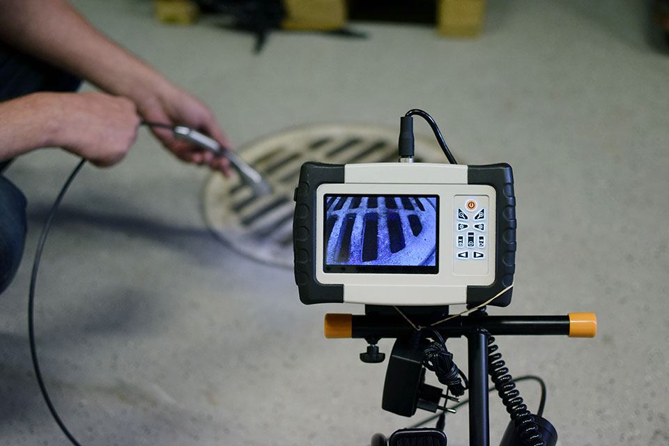 A plumber inserting a drain camera into a drain